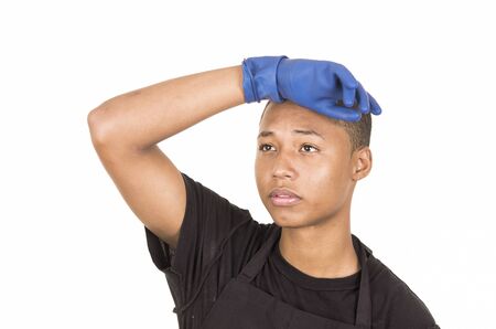 Hispanic young man wearing blue cleaning gloves facing camera with right arm raised.の写真素材