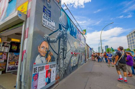 BERLIN, GERMANY - JUNE 06, 2015: Unidentified people looking to Berlin wall, actually full of graffitis, little shop on the side,のeditorial素材