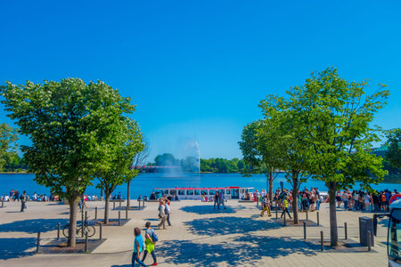 HAMBURG, GERMANY - JUNE 08, 2015: Big bote with people walking around stops at Binnenalster lake, in...