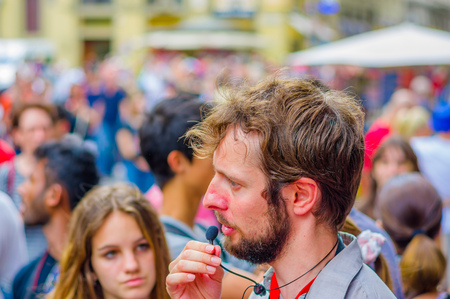 FLORENCE, ITALY - JUNE 12, 2015: Italian tour guide, microphone speaking for a big group of turists. Girl behind paying attention.のeditorial素材