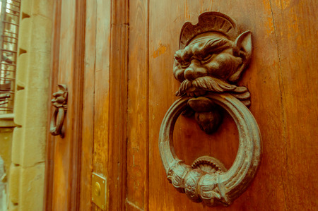FLORENCE, ITALY - JUNE 12, 2015: An old metal door knocker on a wooden door. Lion form with serious face.のeditorial素材