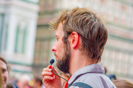 FLORENCE, ITALY - JUNE 12, 2015: Italian tour guide close up, microphone speaking for a group,...