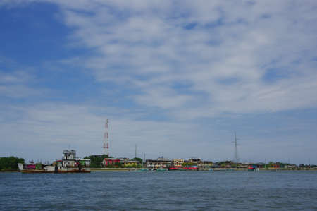 Muisne, Ecuador - March 16, 2016: Looking across water from island with mainland visible in distance, beautiful blue sky.のeditorial素材
