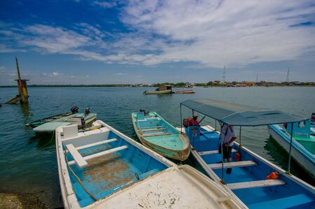 Muisne, Ecuador - March 16, 2016: Several typical fishingboats parked at local pier with pacific ocean background.のeditorial素材