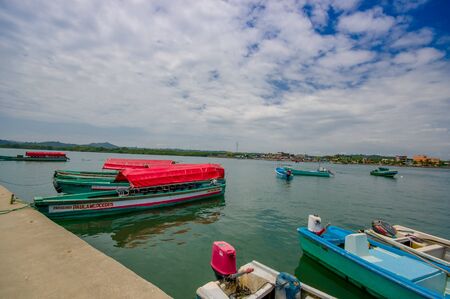 Muisne, Ecuador - March 16, 2016: Several typical fishingboats parked at local pier with pacific ocean background.のeditorial素材
