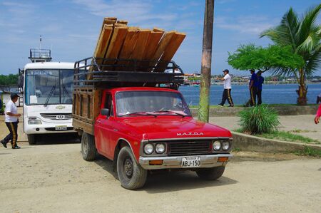 Muisne, Ecuador - March 16, 2016: Pickup truck and police bus arriving from mainland ferry.のeditorial素材