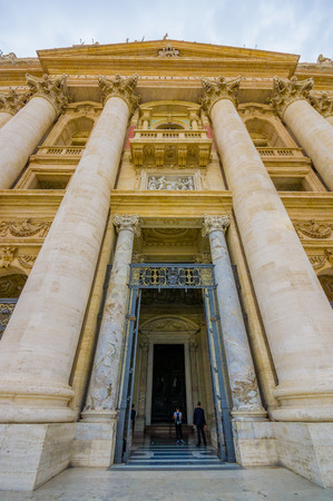 VATICAN, ITALY - JUNE 13, 2015: Big and imposing main door to enter inside Saint Peter Basilica at Vatican. Huge side columns and gold decoration.のeditorial素材