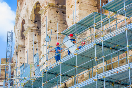 ROME, ITALY - JUNE 13, 2015: Mens working outside Roman Coliseum, reconstruction hand works.のeditorial素材
