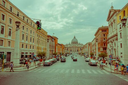 VATICAN, ITALY - JUNE 13, 2015: Large street with shops on the sides, at the end Saint Peter basilica in a cloudy day.のeditorial素材