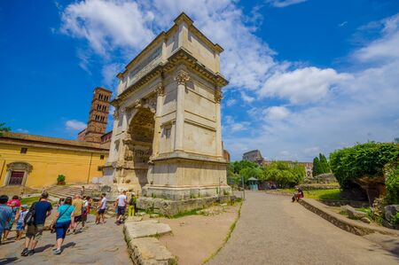 ROME, ITALY - JUNE 13, 2015: People enter to Roman Forum, big stone arch with roman letters. Trees all around the place.のeditorial素材