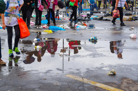 QUITO, ECUADOR - JULY 7, 2015: After raining water puddle stay on the street, people shadows on them, and walking on the sides.のeditorial素材