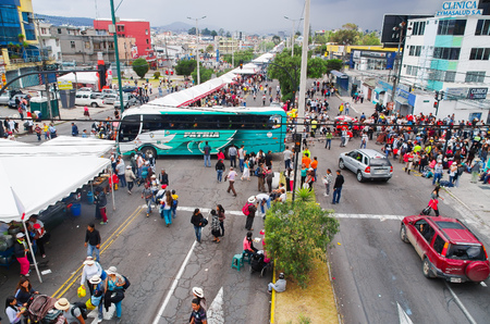 QUITO, ECUADOR - JULY 7, 2015: Cars an buses trying to pass in the middle of a crowded street, people walking to arrive to pope Fransisco mass.のeditorial素材