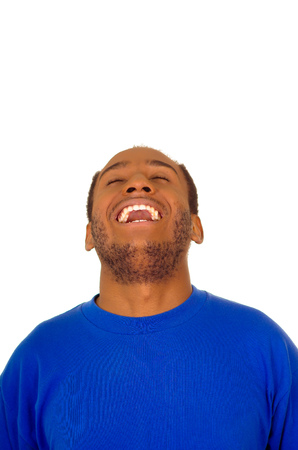 Headshot man wearing strong blue colored t-shirt laughing hard while tilting head backwards, white studio background.の写真素材