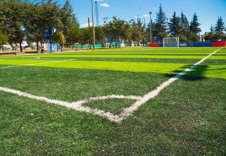 QUITO, ECUADOR - 8 AUGUST, 2016: Great perspective of artificial grass football field located in inner city park La Carolina, taken from corner flag showing trees and buildings, beautiful sunny day.の写真素材