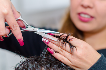 Metal scissors helping a hairstylist to make a nice haircut, close up.の写真素材