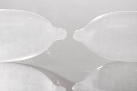 Closeup transparent condom filled with air lying on white surface, studio background, sexual safety concept,.の写真素材