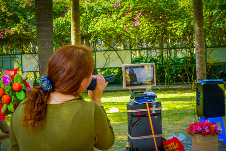 SHENZEN, CHINA - 29 JANUARY, 2017: Lian Hu Shan neighborhood, woman singing karaoke in park areaのeditorial素材