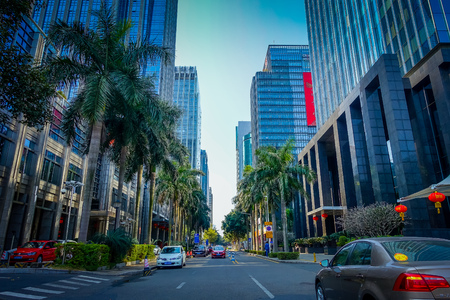SHENZEN, CHINA - 29 JANUARY, 2017: Inner city streets and sorroundings, beautiful mix of green trees combined with buildings, modern architecture, light traffic, totally blue skiesのeditorial素材