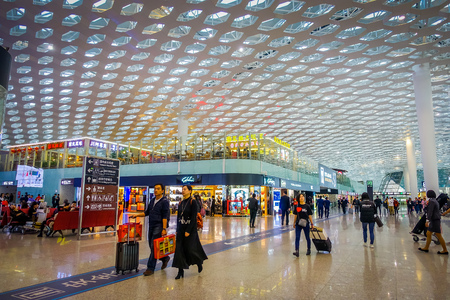 SHENZEN, CHINA - 29 JANUARY, 2017: Inside airport terminal connection halls, modern interior architecture design, glass mixed with white panels, shops restaurants and some people aroundのeditorial素材