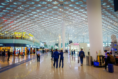 SHENZEN, CHINA - 29 JANUARY, 2017: Inside airport terminal connection halls, modern interior architecture design, glass mixed with white panels, shops restaurants and some people aroundのeditorial素材