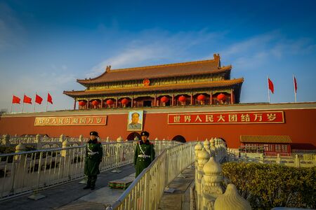 BEIJING, CHINA - 29 JANUARY, 2017: Beautiful temple building inside forbidden city, typical ancient Chinese architecture, picture of Mao hanging on facade, soldiers standing guard.のeditorial素材