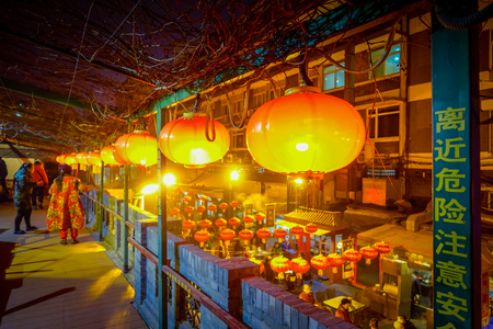 BEIJING, CHINA - 29 JANUARY, 2017: People walking around charming streets with small restaurants, traditional architecture and decorations, local Donghuamen food market concept.のeditorial素材