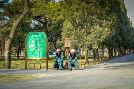 BEIJING, CHINA - 29 JANUARY, 2017: Guards wearing green uniform coats and helmets sitting resting inside temple of heaven compound, imperial complex with various religious buildings located in southeastern central city area.のeditorial素材