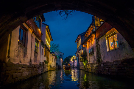 SHANGHAI, CHINA: Beautiful evening light creates magic mood inside Zhouzhuang water town, ancient city district with channels and old buildings, charming popular tourist areaの写真素材