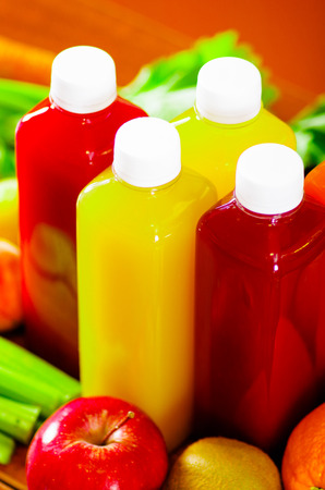 Bottles of delicious organic juice sorrounded by fruits and veggies, beautiful colors, healthy lifestyle conceptの写真素材