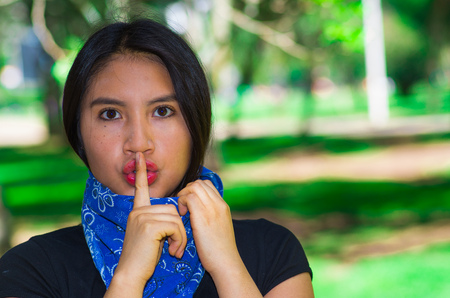 Young brunette woman wearing blue bandana around neck, interacting silence outdoors for camera, activist protest conceptの写真素材