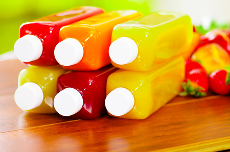 Close up top of juice bottles lying down stacked, beautiful colors and healthy conceptの写真素材