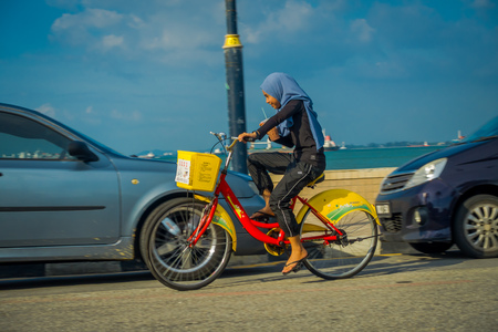 George Town, Malaysia - March 10, 2017: scenic view of unknown muslim women riding bicycles  , a waterfront location in the heart of the city.のeditorial素材