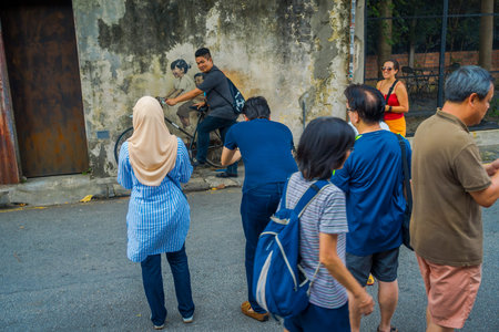 George Town, Malaysia - March 10, 2017: Little Children on a Bicycle, popular mural street art that unknown tourists like to photograph.のeditorial素材