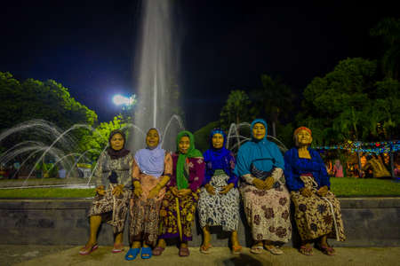 BANYUWANGI, INDONESIA: Charming park area with green vegetation and popular water fountain, people enjoying, beautiful blue evening sky in backgroundのeditorial素材