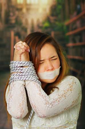 Beautiful young hispanic woman tied and mouth tapedの写真素材