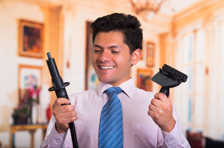 Handsome young Man at home fixing a vacuum cleanerの写真素材