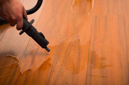 cleaning water on the wood floor with vacuum cleanerの写真素材