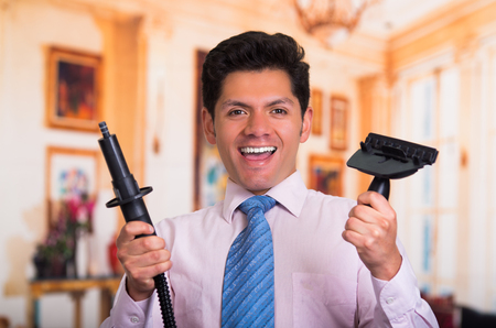 Handsome young Man at home fixing a vacuum cleanerの写真素材
