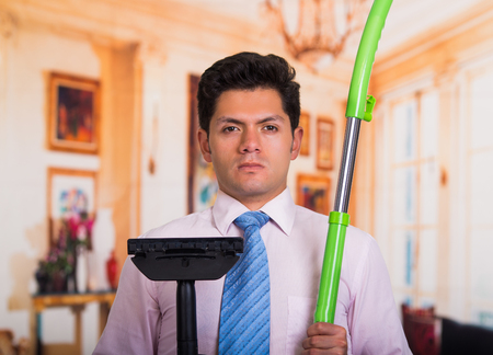 Handsome young mad Man holding vacuum cleanerの写真素材