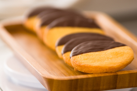 Closeup of a delicious fresh vanilla cookie with chocolate on wooden deskの写真素材