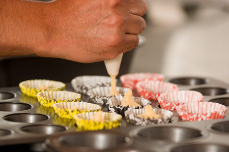 A bakery man is preparing a delicious christmas cookies in a bakery store, adding Dough inside of...