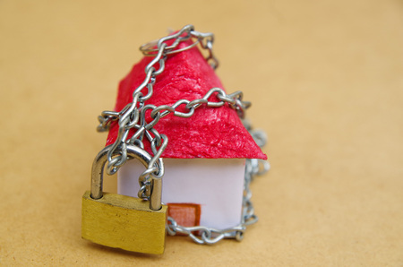 House in chains locked with padlock, mortgage and foreclosure conceptの写真素材