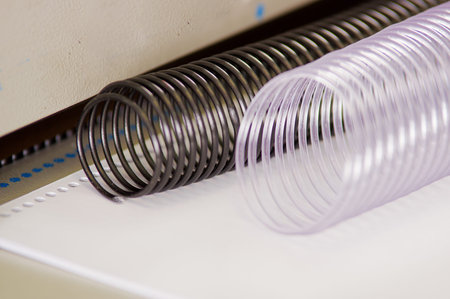 Two useful plastic binding combs white and black on a Binding machine