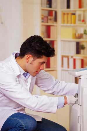 closeup shot young male technician repairing digital photocopier machineの写真素材