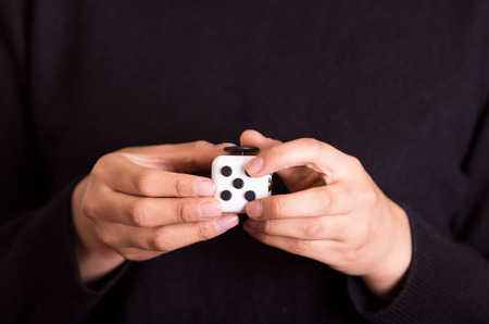 Quito, Ecuador - February 10, 2017: Fidget Cube stress reliever manipulated with both handsのeditorial素材