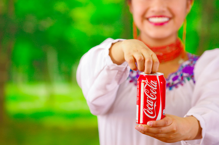 Quito, Ecuador - May 06, 2017: Beautiful smiling indigenous woman drinking a coke in a forest backgroundのeditorial素材