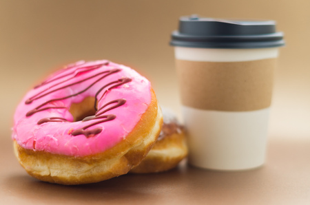Delicious donut with pink glazed, with a cup of hot chocolateの写真素材