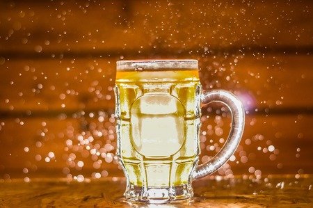 Close up of a blonde craft beer filled into a pint glass on wooden backgroundの写真素材