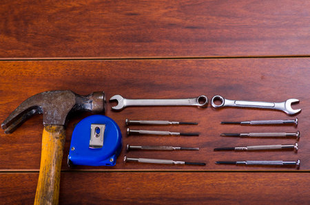 Construction tools,Flat wrenches, hammer, tape measure on wooden backgroundの写真素材