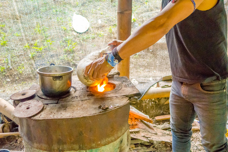 Santa Ana, Ecuador - May 07, 2017: A shaman burning the skin of the armadillo, preparing the food for lunch using fireのeditorial素材
